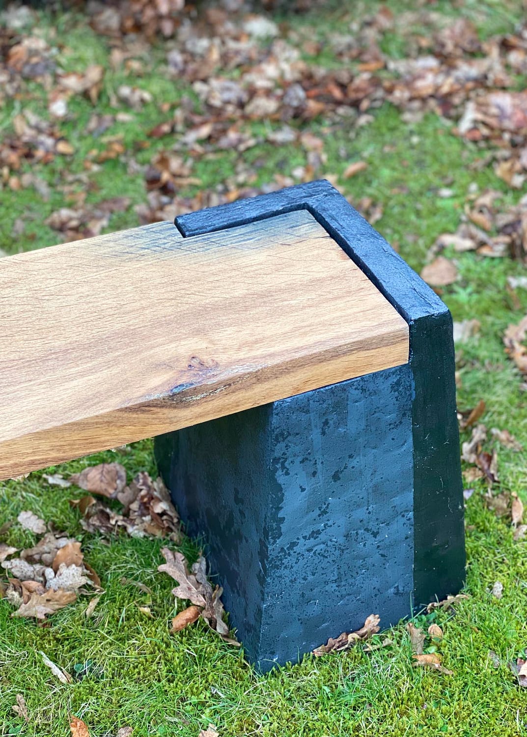 Træplanke på sort bænkestolpe på en græsplæne